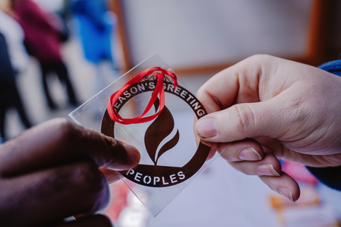 A volunteer hands out a commemorative ornament from Peoples, an Essential Utilities' company, during the 2023 Peoples Gas Holiday Market. The ornaments were given as a complimentary gift to donors to the Greater Pittsburgh Community Food Bank. (Photo: Business Wire)