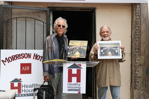 John Densmore, drummer for The Doors, and photographer Henry Diltz share Morrison Hotel memorabilia during a ceremony celebrating AHF’s acquisition of the historic Morrison, a 1914 Single Room Occupancy (SRO) building in downtown Los Angeles on Tuesday, December 19, 2023. The Doors and photographer Henry Diltz made the Morrison famous with the band’s release of its landmark 1970 album featuring Diltz’s iconic cover photo. AHF purchased the gutted building for its Healthy Housing Foundation, saving the Morrison from demolition and, via adaptive reuse, will now convert it into 111 units of low-income housing for people in need. (Photo: Business Wire)