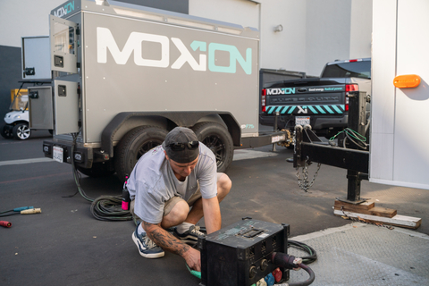 An Amazon Studios crew member plugs in a Moxion Power battery on the set of an Amazon Studios film. (Photo: Business Wire)