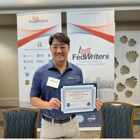 FedWriters President and CEO Mitchell Cho holds the company's Small Business of the Year award from NOAA. (Photo: Business Wire)