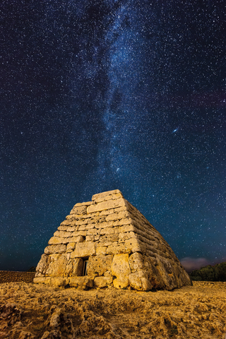 Stars glitter above Naveta des Tudons, Menorca’s most famous burial monument, built by the Talayotic culture long before the Roman Empire. (Photograph by Sebastián Iturralde)