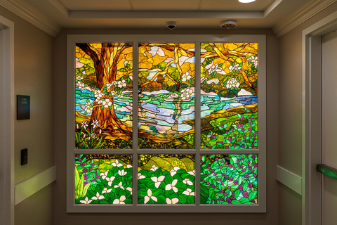 The 'In Memory of Kirk Mauro, M.D., Diane Mauro and Family', Stained Glass at the First Commerce Center for Compassionate Care. This piece was commissioned by Big Bend Hospice from Florida State University’s Master Craftsman Studio. The custom stained-glass piece took over 1,400 hours of labor to create. It features plants native to Tallahassee and the Big Bend region. (Photo: Business Wire)