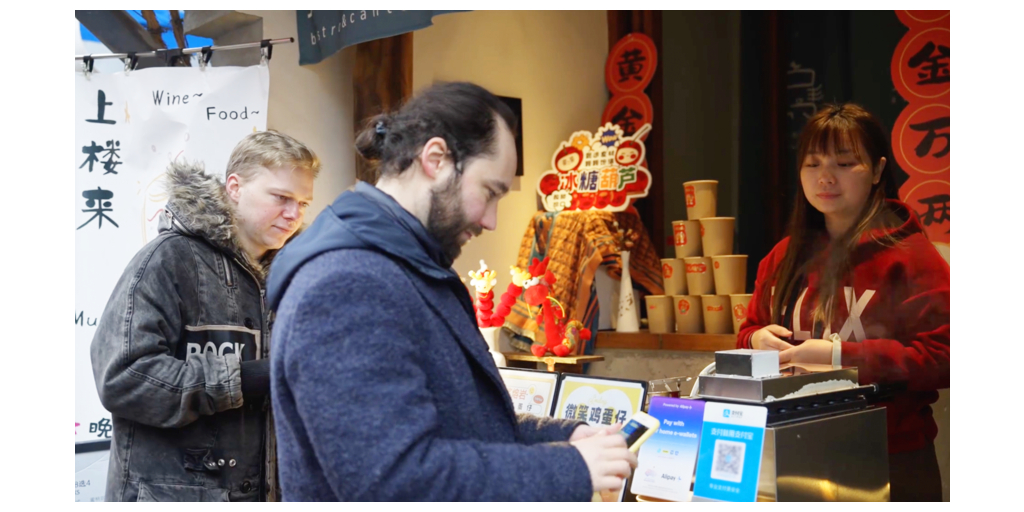 International visitors paying with Alipay at a food merchant in China