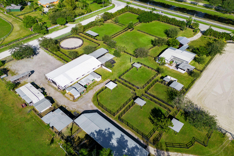 All horse farm structures are located on one of the two parcels, shown here. Amenities include a 150-ft x 250-ft arena, round pen, 18 stalls, and 8 paddocks with shade stands. There is also a small guesthouse on the parcel (shown at upper right). WellingtonLuxuryAuction.com. (Photo: Platinum Luxury Auctions)