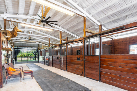 This center aisle barn is one of two barns on the property. In total, the barns offer 18 stalls plus a tack room and wash station. WellingtonLuxuryAuction.com. (Photo: Platinum Luxury Auctions)