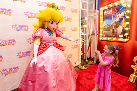 In this photo provided by Nintendo of America, June E., 4, and Princess Peach celebrate the launch of the Princess Peach: Showtime! game at the Nintendo New York store in Rockefeller Center. The weekend-long event, which features gameplay on the Nintendo Switch system and theatrical photo ops, runs through March 24.