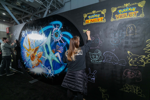 In this photo provided by Nintendo of America, Shaylin D. adds to a Pokémon Scarlet and Pokémon Violet themed mural at PAX East.