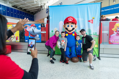 In this photo provided by Nintendo of America, Mario, the mustached hero of the Mushroom Kingdom, stops by to greet families at the “Nintendo Switch On the Go” popup in JetBlue’s Terminal 5 in John F. Kennedy International Airport in New York City.