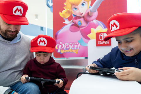 In this photo provided by Nintendo of America, families play games together at the “Nintendo Switch On the Go” popup in JetBlue’s Terminal 5 in John F. Kennedy International Airport in New York City.