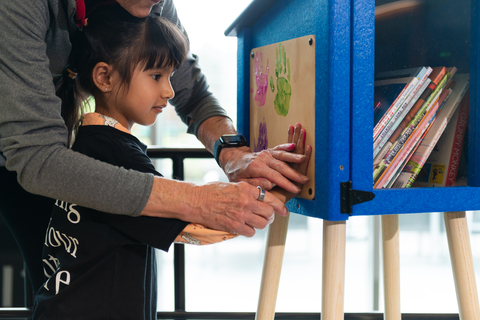 Preschool student painting Little Free Library book-sharing box. (Photo: Business Wire)