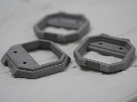 These watch cases are binder jet 3D printed on Desktop Metal technology using 6061 aluminum powder produced by Kymera International. The watch cases are shown here immediately after 3D printing and before final sintering. (Photo: Business Wire)