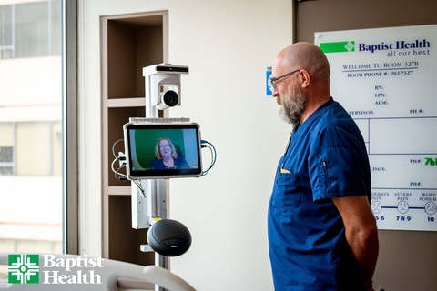 A Baptist Health bedside care team member welcomes a virtual clinician into the patient room using Caregility’s APS250C mobile telehealth cart. (Photo: Business Wire)