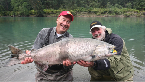 滾石樂團鍵盤手 Chuck Leavell（右）在加拿大不列顛哥倫比亞省與 Johnny Morris（左）一起捕魚時所捕獲的壯觀帝王鮭魚，並隨後將之釋放（照片：美國商業資訊）