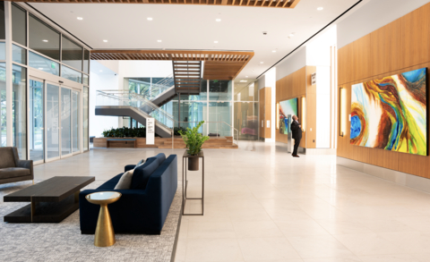 Gone are the clunky stairways and stone-clad arches. 5POP's new lobby and main entrance features glass curtain walls carrying an abundance of natural light, a single floating staircase, and sophisticated artwork. (Photo: Business Wire)
