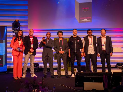 The Tiami Networks team holding their award on stage with representatives from the Deutsche Telekom T Challenge. (Photo: Business Wire)