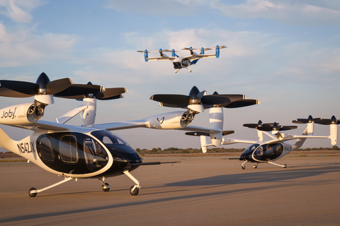 Two of Joby’s battery-electric production prototype aircraft in Marina, California, with the company’s hydrogen-electric technology demonstrator in flight above. Joby Aviation Photo