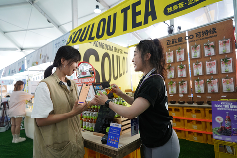 A Malaysian visitor using Touch 'n Go eWallet to sample Chinese tea at the Green Market during the INCLUSION Conference (Photo: Business Wire)