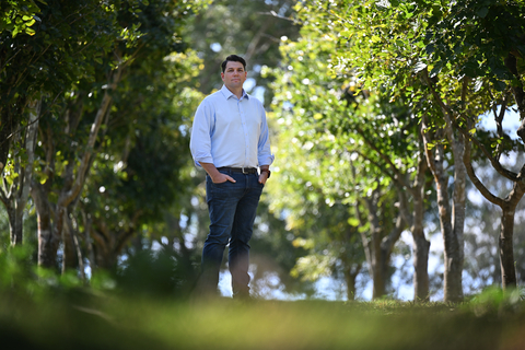 Rio Tinto Chief Decarbonisation Officer Jonathon McCarthy flanked by Pongamia trees. The Pongamia pilot will explore the potential of Pongamia seed oil as a feedstock for renewable diesel, a cleaner alternative to traditional fossil fuels.