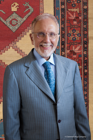 original Claremont Rug Company founder/president seated in front of an early 19th-century Dragon and Phoenix Bakshaish carpet that he discussed on the podcast "Curious Objects," published by The Magazine Antiques. (Photo: Business Wire)
