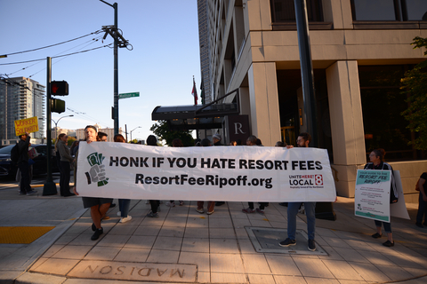 Hotel workers hold a banner reading “Honk if you hate resort fees” (Photo: Business Wire)