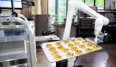 Demonstrating its impressive 1,418 mm of reach, the FANUC CRX-20iA/L Food-Grade Cobot uses a bakery tray to catch cookies coming off the end of the conveyor and place the full trays onto a cart in this bakery demonstration. (Photo: Business Wire)