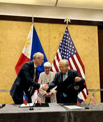 UltraPass CEO, Eric Starr (L), shakes hands with Secretary of Transportation, Jaime Bautista (R), after signing the partnership agreement in Manila. (Photo: Business Wire)