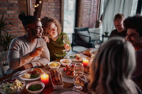 Family and friends enjoy meal at dinner table during holidays. (Photo: Business Wire)