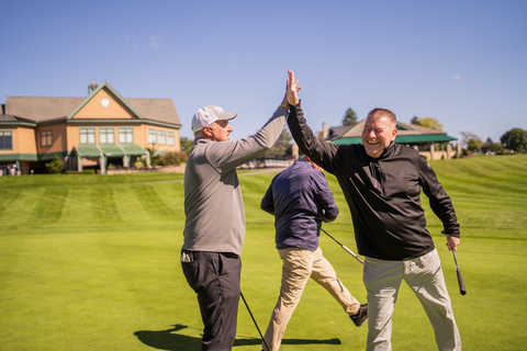 Golfers celebrate a made putt at the MITER Foundation charity golf outing in Hershey (Photo: Business Wire)