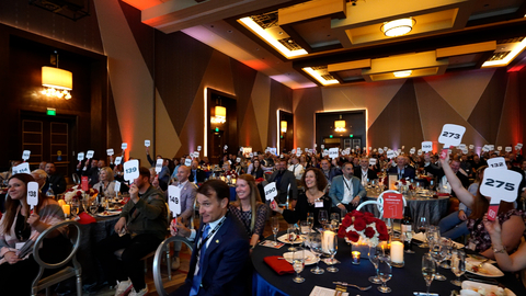 Prospective bidders hold up their paddles during the MITER Foundation’s live auction at its charity event in Temecula (Photo: Business Wire)