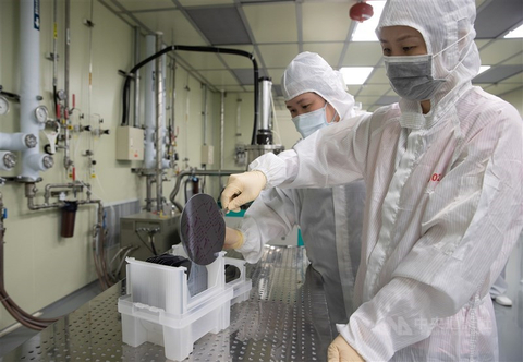 Technicians examine silicon wafers in a fabrication plant in Taiwan. CNA file photo