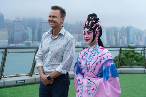 The Amazing Race host Phil Keoghan and a traditional Chinese opera singer greet contestants at the West Kowloon Cultural District in Hong Kong. Photo Credit Kit Karzen CBS.