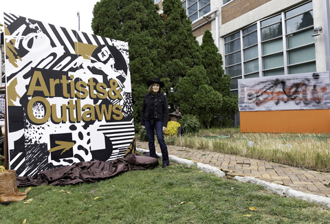 Advertising industry veteran Shari Day poses with a custom mural created to launch bohan’s rebrand as Artists&Outlaws. Day is president and CEO of the Nashville-based agency.