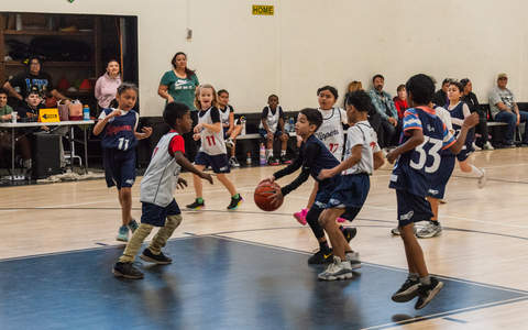 thumbnail Jóvenes jugadores de baloncesto mixto jugando juntos. Forman parte de los programas deportivos juveniles PlayLA y visten camisetas con la marca de los LA Clippers.