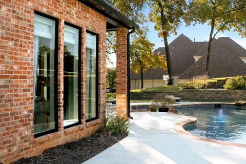 original Our BlackCore™ by Elevate product showcases true black frames against traditional brick, adding visual drama and emphasizing the home’s architectural character.