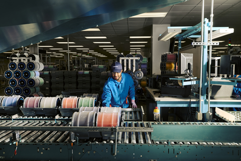 original Employee processing fiber at a Corning optical fiber manufacturing facility.
