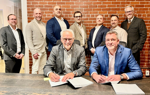 Martin Jacques, COO at Pomerleau, and Eric Desaulniers, President & CEO of NMG, officialize a new collaboration chapter in presence of key team members.