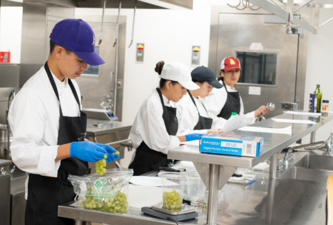 Learn4Life high school students practice culinary skills taught by a chef, highlighting the popularity of CTE courses that are facing a shortage of credentialed industry professionals to teach