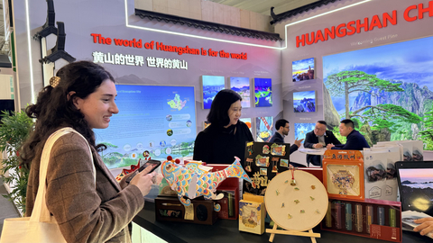 International visitor admires Huangshan cultural and creative exhibits at the Huangshan stand during ITB Berlin.