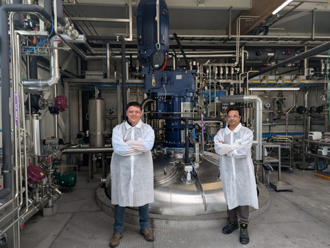 Equipe da Cemvita, Luciano Zamberlan, Vice-Presidente de Engenharia, e Nymul Khan, Diretor de Tecnologia, na Bio Base Europe Pilot Plant, ao lado do fermentador de 75.000 litros.