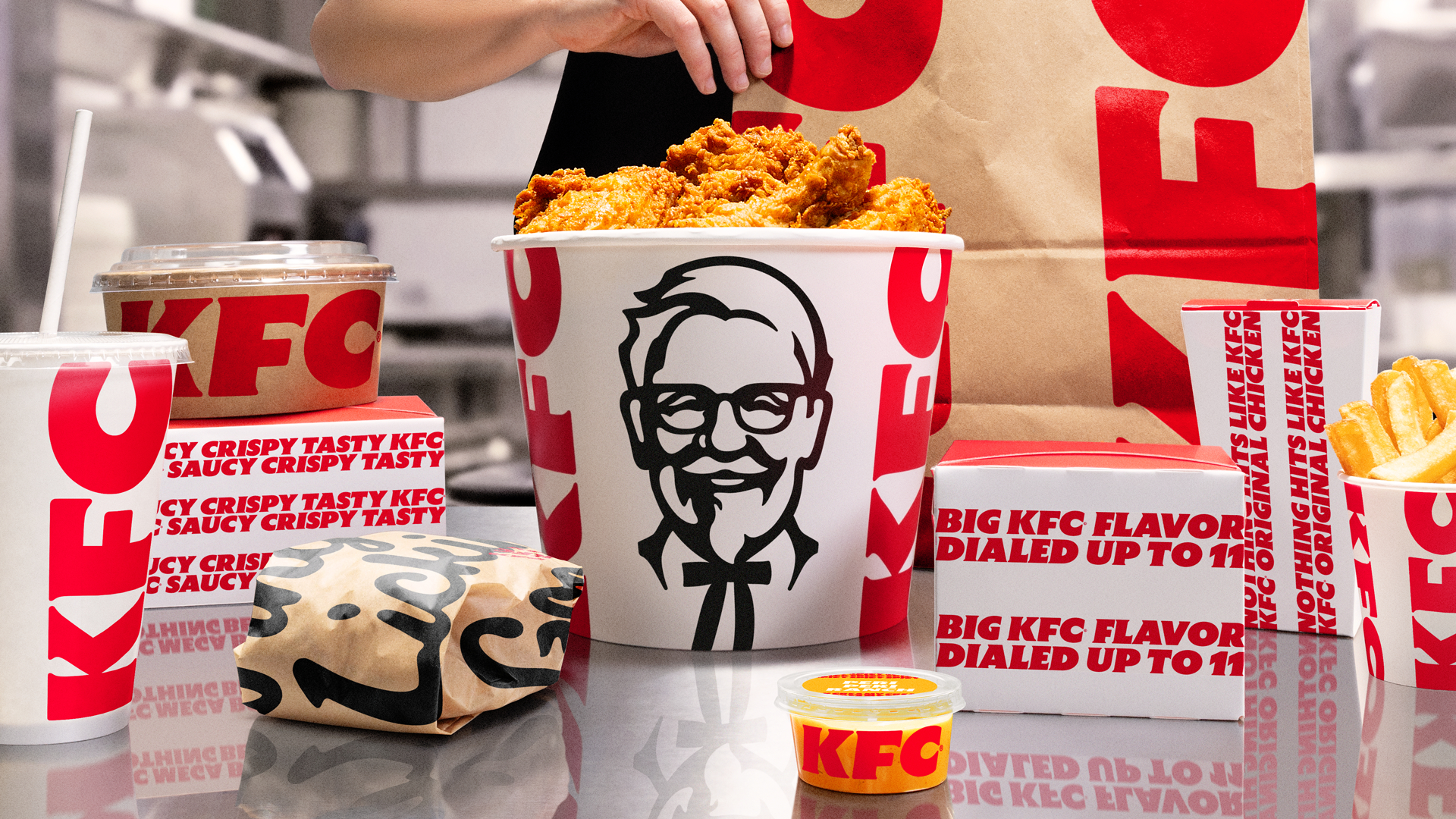 KFC’s updated visual identity extends across packaging – turning bags, cups, boxes and its iconic bucket into bold branded touchpoints.