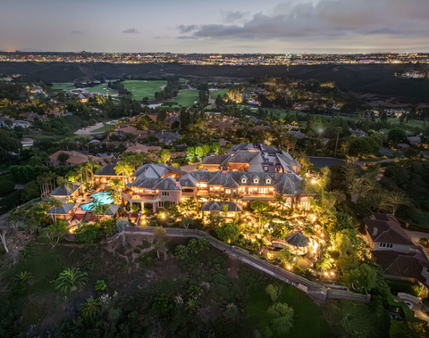 "The Eagle's Nest," represented by Tim Van Damm of Berkshire Hathaway HomeServices California Properties, is a remarkable Rancho Santa Fe estate perched atop one of the area's highest hills, offering breathtaking 360-degree ocean, golf course, and mountain views. Located on a private gated street, the estate showcases exceptional craftsmanship, impeccably manicured grounds, and materials sourced from around the world. Amenities include a home theater, two-story library, rooftop deck, fitness center, private guest quarters, and spectacular fountains. The property exemplifies luxury living at its finest. Photo Credit: Shay Blechynden.