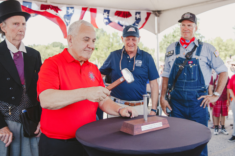 original Union Pacific CEO Jim Vena drives the ceremonial Silver Spike as a Charles Carroll actor, left; Richard Anderson, chairman of the Norfolk Southern board of directors; and Ed Dickens, senior manager-Heritage Operations, Union Pacific, look on.