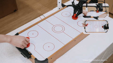 A robot powered by LingBot-VA 2.0 engages in a real-time tabletop air hockey match with a human
