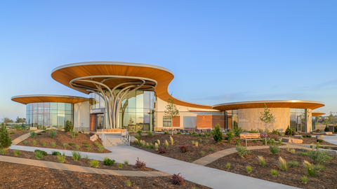 original Exterior rendering of the Anythink Libraries Nature Library in Thornton, Colorado, opening August 8, 2026. Designed as a first-of-its-kind public library experience, the 33,000-square-foot building sits on a 15-acre campus next to Aylor Open Lands and reimagines what a modern library can be. The architecture draws from natural forms, with circular structures, expansive glass and landscaped gardens that invite movement between indoor and outdoor spaces. Visitors will have access to a one-mile walking trail, outdoor learning areas and nature-based programming that extends beyond traditional library services. The Nature Library positions Adams County at the forefront of library innovation, combining community space, environmental education and accessible outdoor experiences in a single destination designed for all ages.