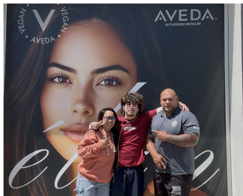 original Former Learn4Life student Johnny G., center, pictured with his boss and co-worker, unveils a storefront installation he designed. Thanks to his high school graphic arts classes, he was hired upon graduation and is flourishing in his chosen career.