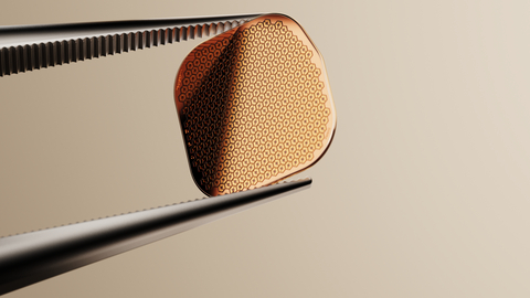 original The PRIMA implant held between tweezers (Photo Credit: Science Corporation)