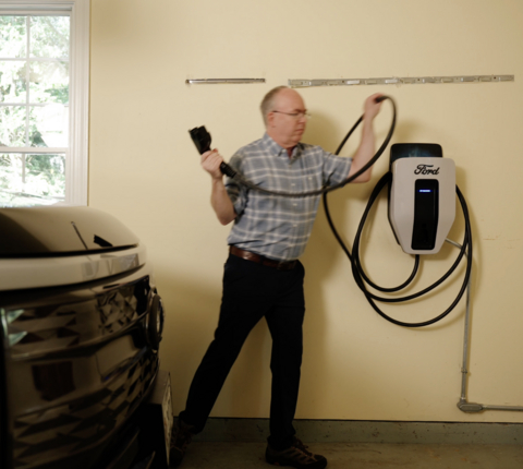 A driver participating in a vehicle-to-grid program that utilizes Sunrun smart charging technology plugs in their vehicle.