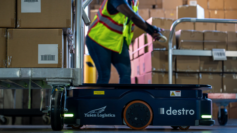 original A Destro autonomous robot operating alongside a warehouse associate at a Yusen Logistics facility, demonstrating the companies’ collaboration to improve warehouse operations through intelligent automation.
