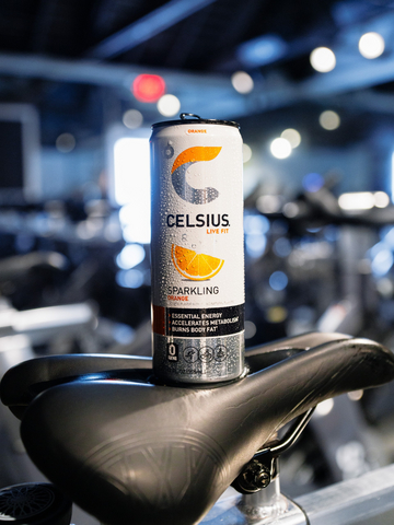 original Sparkling Orange CELSIUS sitting on a SoulCycle bike.
