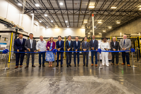 Attendees participate in a ribbon-cutting ceremony to celebrate the completion of the facility.
